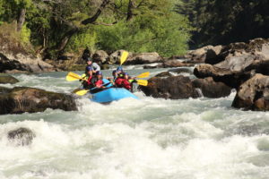 Grupo de personas en una balsa de rafting bajando el río