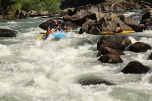 Grupo de personas en una balsa de rafting bajando el río