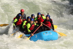 Grupo de personas en una balsa de rafting bajando el río