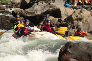 Grupo de personas en una balsa de rafting bajando el río