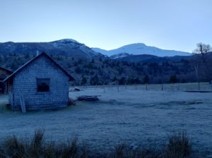 Base del volcan Quetrupillan, antes de empezar el ascenso - Se ve una casa de madera y el volcan en el fondo - Ermitaño Expediciones